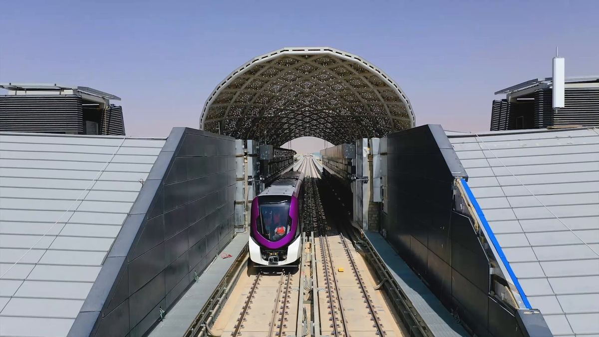 Purple Line 6 train leaving a station with a domed canopy